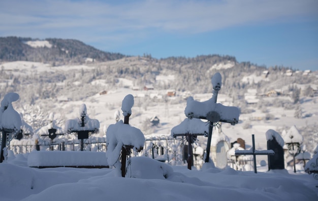 山の墓地で雪に覆われた墓地の十字架の眺め