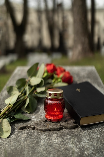 View of gravestone with flowers and candle