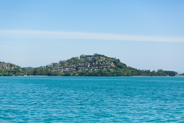 View of a green island in the blue ocean. (NO TAGS WITH LINES. MAX 2 WORDS)