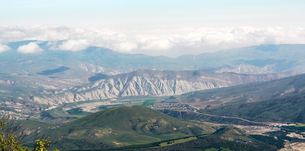 계곡의 푸른 산과 마을의 전망. 광각 파노라마