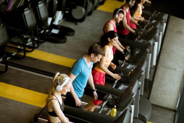 Above view at group of young people running on treadmills in modern sport gym