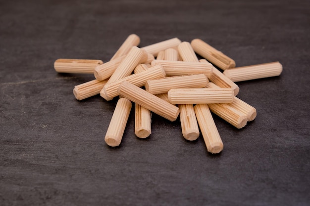 View of a grouping of wooden dowels on grey background Closeup