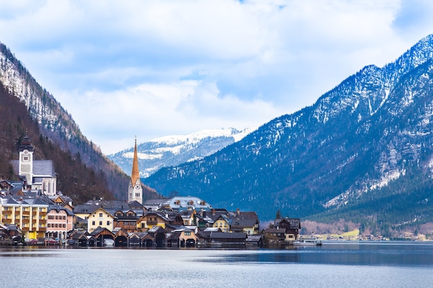 早い春の素敵な日に湖と山でオーストリアのHallstat町の景色