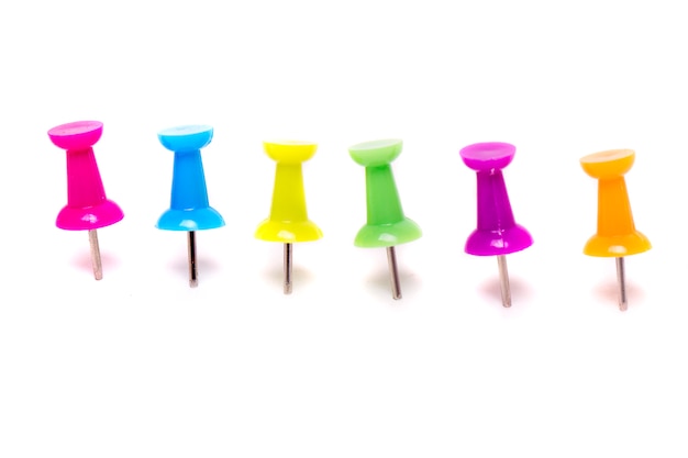 View of a horizontal line of pinned colorful push pins isolated on a white background.