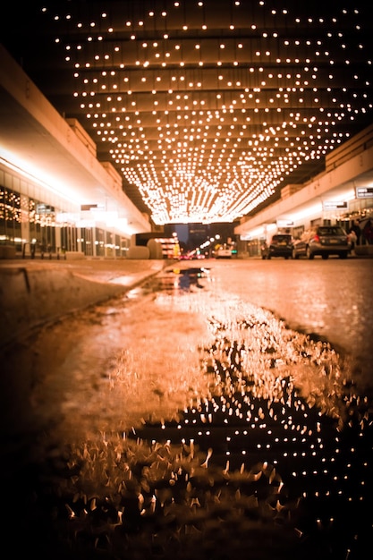 Foto vista della luce illuminata del soffitto che si riflette nell'acqua sulla strada