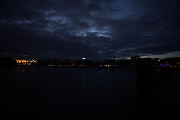 View of illuminated cityscape against cloudy sky