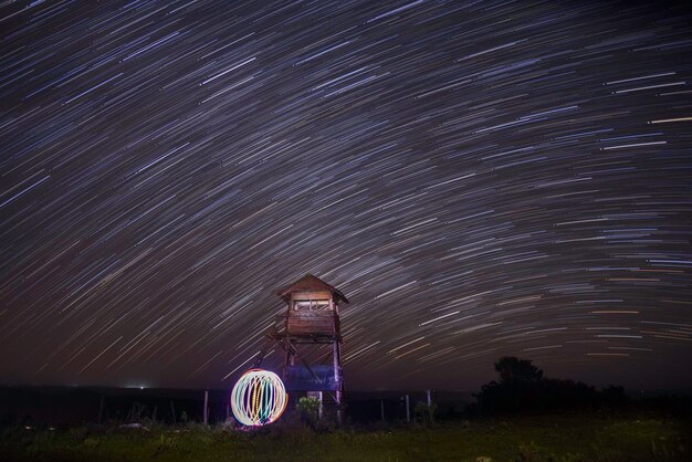 Photo view of illuminated field against sky at night