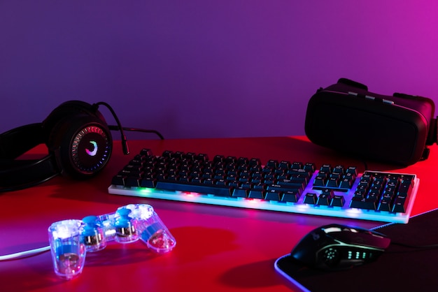 View of illuminated neon gaming keyboard setup and controller