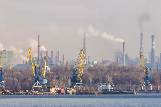 Vista della città industriale di zaporozhye, ucraina. emissioni di smog dai camini, inquinamento atmosferico. situazione ambientale scadente. stabilimenti metallurgici e porto mercantile