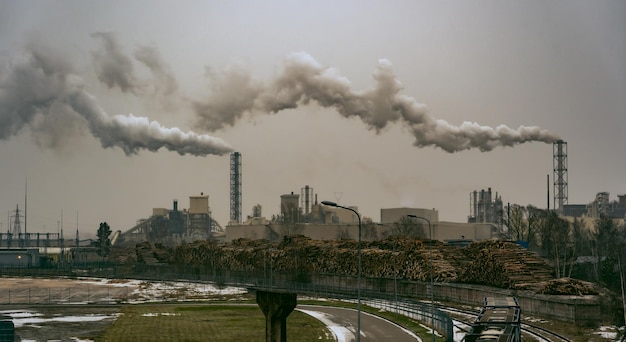 Foto vista sui gas di scarico della ciminiera del fumo di inquinamento della fabbrica industriale fabbrica di lavorazione del legno