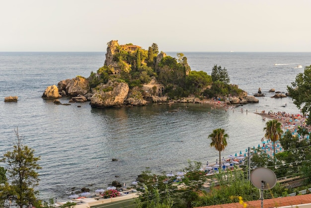 イタリア、シチリア島、タオルミーナの近くの小さな島、ベッラ島の景色。イオニア海の小さな湾内に位置し、狭い道で本土のビーチに接続されています