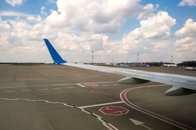 View of jet airplane wing taxiing runway after landing at airport.