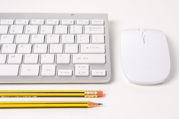 View of keyboard and mouse of a modern computer with pencils