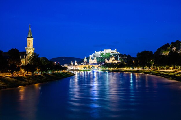 View of lake against illuminated buildings at night