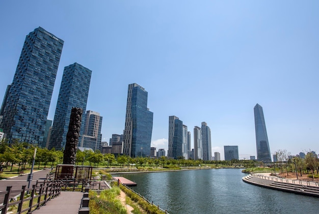 View of lake by modern buildings against blue sky