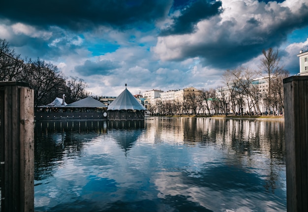 View of a lake in a city on a cloudy day