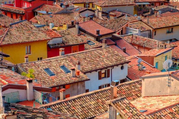 View of lake Garda from the tower in the town of Malcesine. Italy. A view of the tiled roofs of the Italian city. Lake Garda. Riva del Garda.