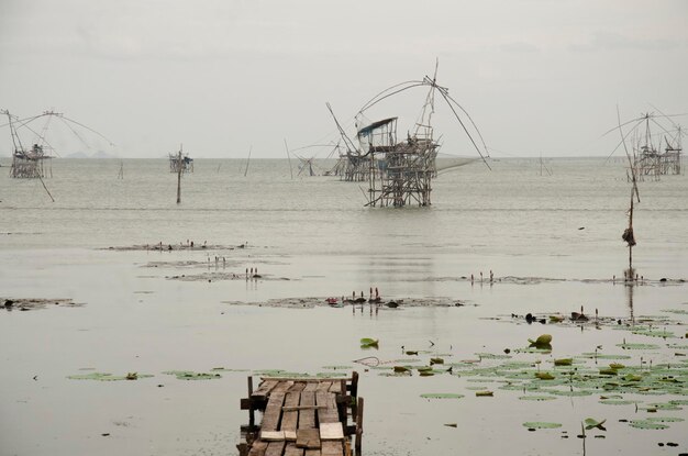 Photo view landscape of fishing lift and dip net machine in pakpra canal at ban pak pra fishing village in dusk time at phatthalung province of southern thailand