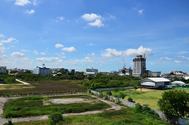 태국 방콕에서 2014년 7월 5일 건설 현장에서 중장비 작업 빌더 새 건물 타워 사무실 콘크리트 구조물이 있는 방콕 시의 조경 잔디밭과 도시 경관을 봅니다.
