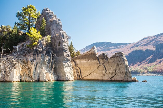 View landscape of lake with turquoise water and  stone sharp rocks.