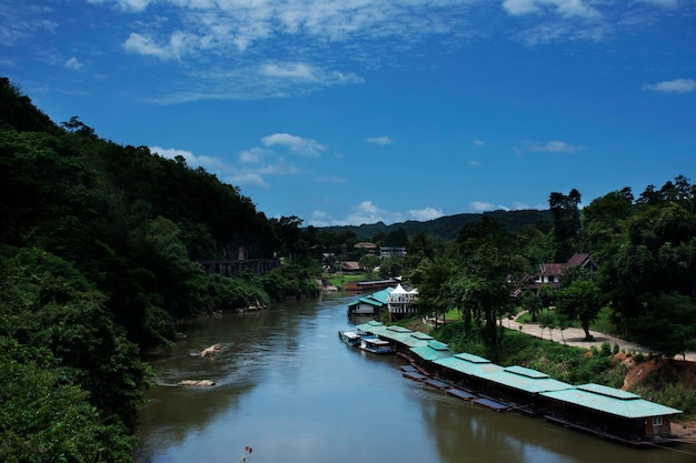 View landscape and raft house float on si sawat or khwae kwai river with hellfire pass mountain forest in Sai Yok Waterfall National Park for travel visit at Tham krasae cave in Kanchanaburi Thailand