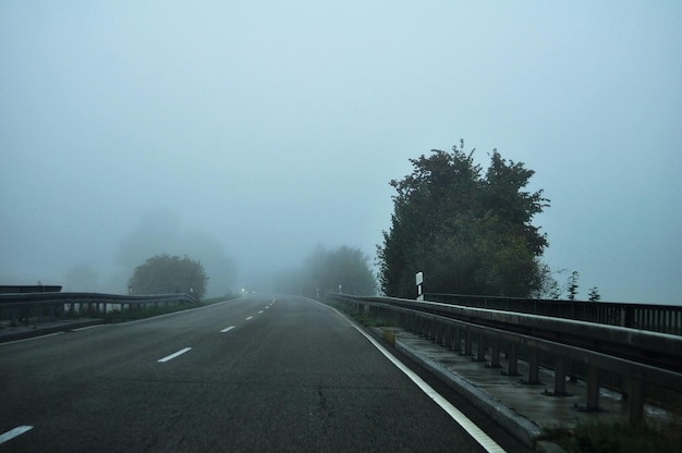 人々が自転車に乗ってドライブするために朝の時間に霧のある風景の交通道路と高速道路を見るドイツとの国境近くのフランスのグランテスト地域にあるストラスブールの首都に行く