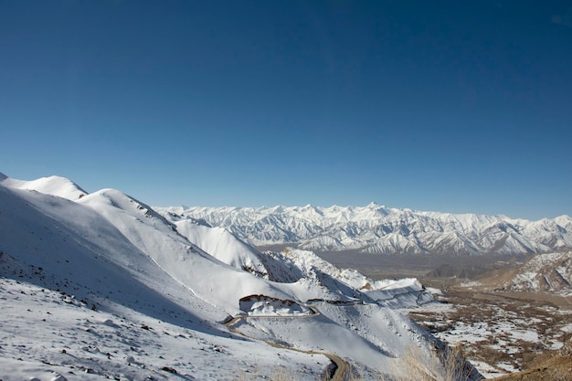 Guarda il paesaggio con la catena montuosa dell'himalaya tra il passaggio stradale di khardung la vai alla valle di nubra nella città di hunder mentre la stagione invernale a leh ladakh in jammu e kashmir india