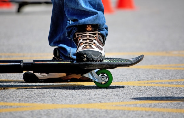 View of the legs of a young street-surfing adept boy on a relaxed pose.