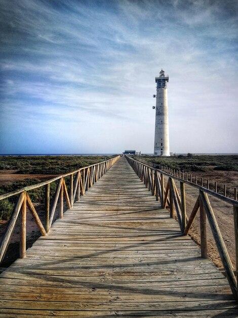 Photo view of lighthouse by sea against sky in fuerteventura