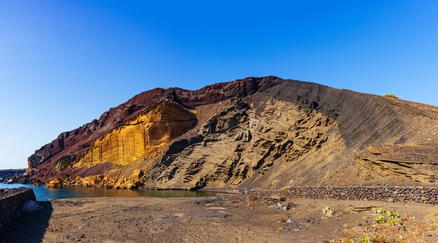 View of the Linosa volcano called Monte Nero in the beach of Cala Pozzolana di Ponente, Sicily