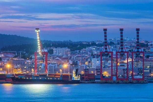 Photo view of lisbon port with ship and port cranes in the evening