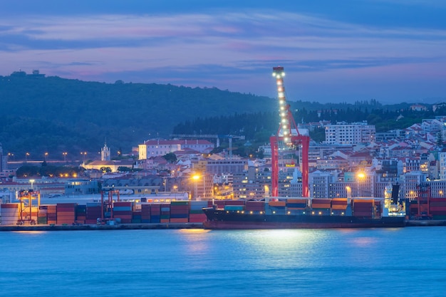 View of lisbon port with ship and port cranes in the evening