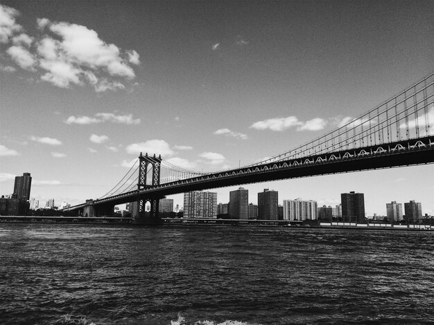 View of manhattan bridge over river in city against sky