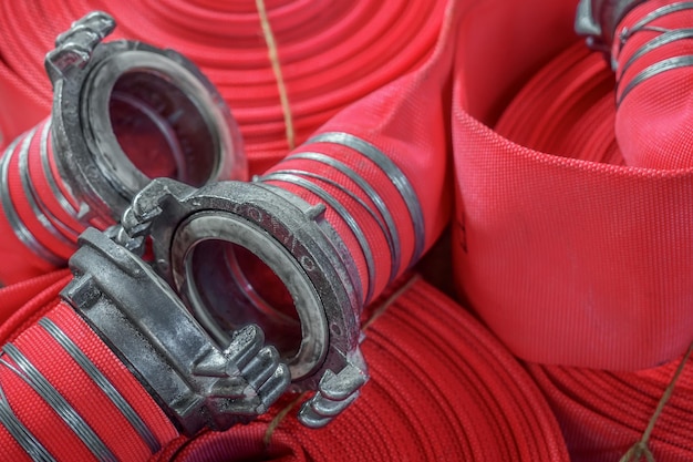 Foto vista di molti tubi antincendio rosso contorto alzato a schermo intero nuove attrezzature antincendio sullo sfondo