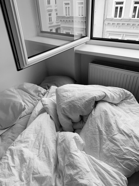 View of messy bed in bedroom