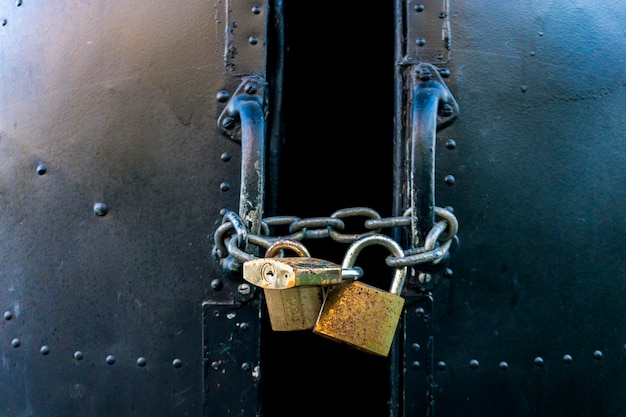 Photo view at metallic locked door with three padlocks