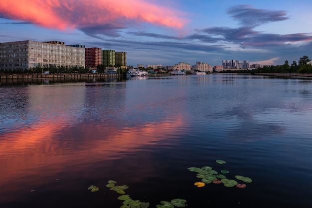 View of modern buildings near the water during sunset.