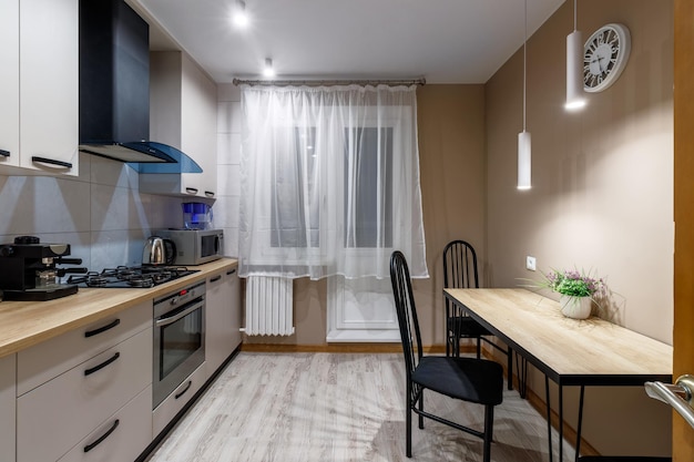 View of a modern kitchen with blue hood kitchen appliances and dining table