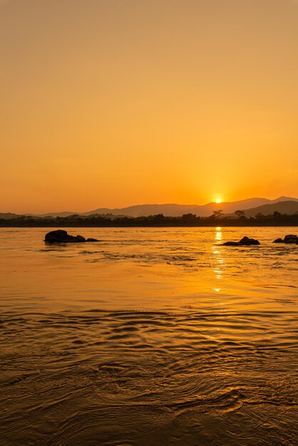 山々に囲まれた朝のメコン川と夕日の黄色い太陽光線の眺め