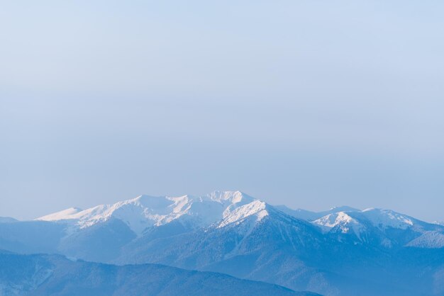 雪の中の山の頂上の眺め コピー スペースのある冬の風景