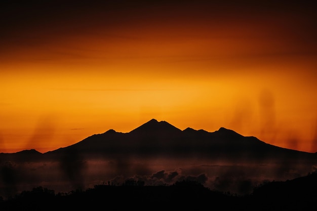 View of mountain with fog at sunset