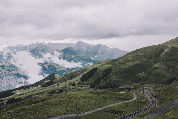 View on mountains from Jungfraujoch station in alps, national park in Lauterbrunnen, Switzerland, Europe. Summer landscape, rainy weather, dramatic clouds sky