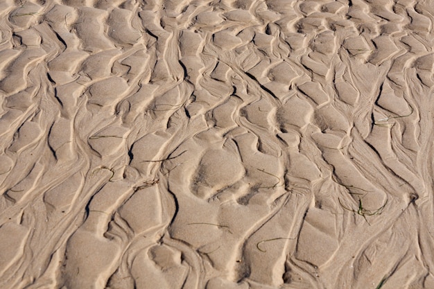 Foto vista delle increspature naturali fatte dalla marea sulla sabbia.