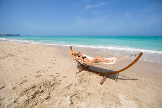 Vista di belle ragazze che dondolano in hummock sulla spiaggia del mare