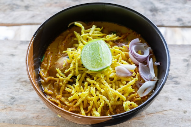 Foto vista della tagliatella con l'alimento del minestra e del pollo (khao soi) del curry della tailandia del nord tradizionale