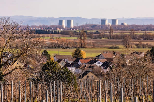 Foto vista di una centrale nucleare con case e vigneti in primo piano