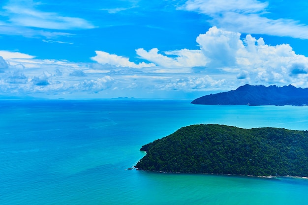 写真 飛行機の窓から海に浮かぶ緑の熱帯の島の眺め。