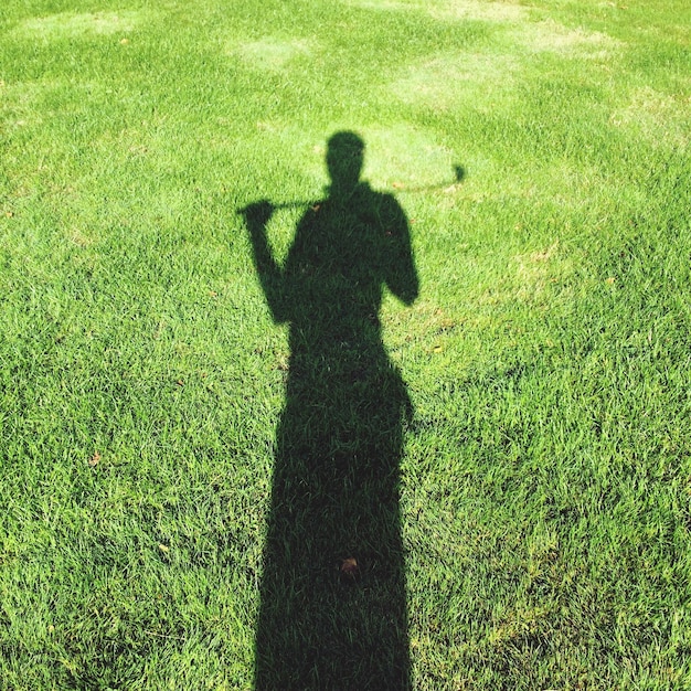 Фото Взгляд на человеческую тень, играющую в гольф