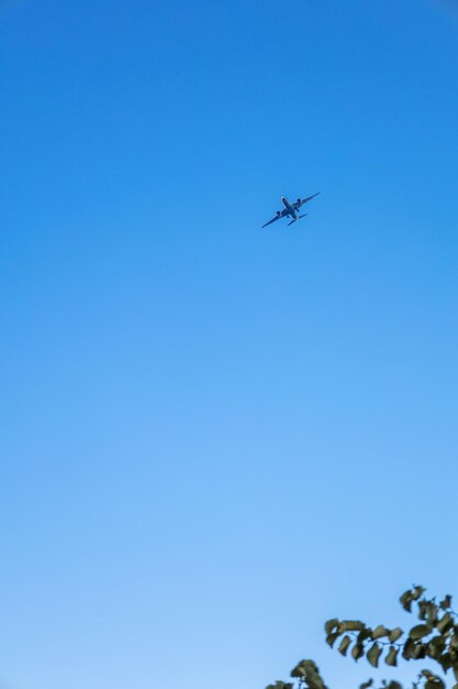 写真 青い空を飛ぶ飛行機の景色 垂直写真
