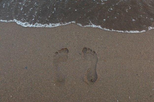 写真 足跡が描かれた夏のビーチサンドの景色